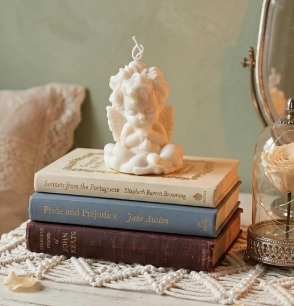 Pura ternura — vela querubín sobre libros